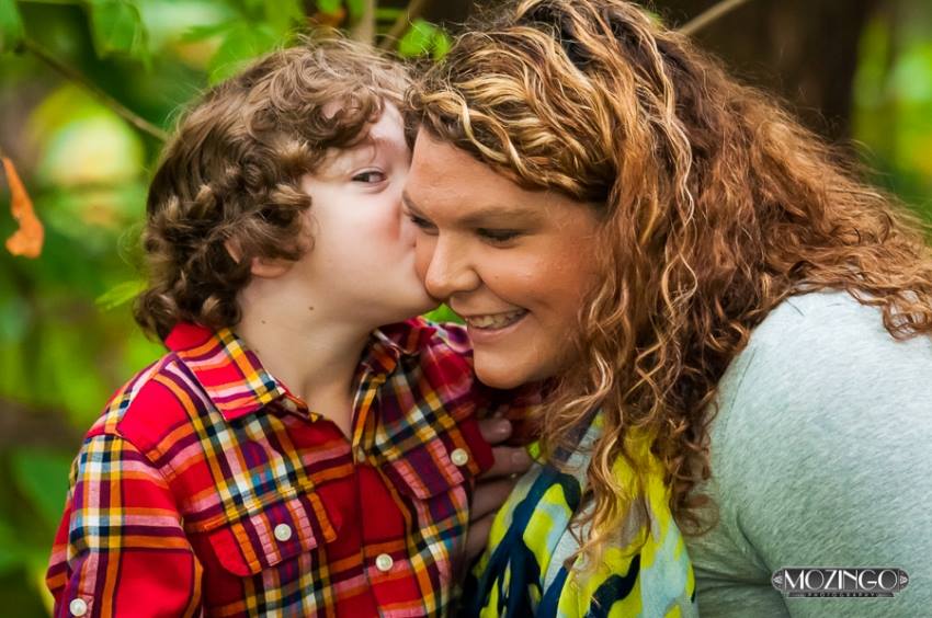 anna williams smiles as her son kisses her on the cheek
