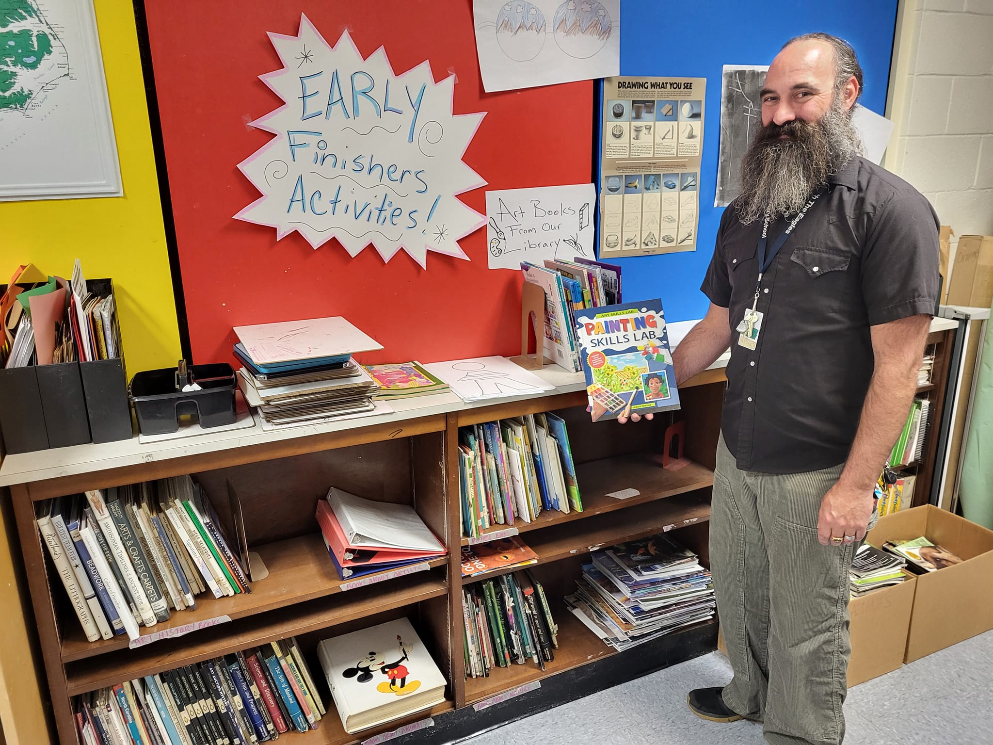 art teacher at haywood county school standing infront of his classroom library supplied by anna's books