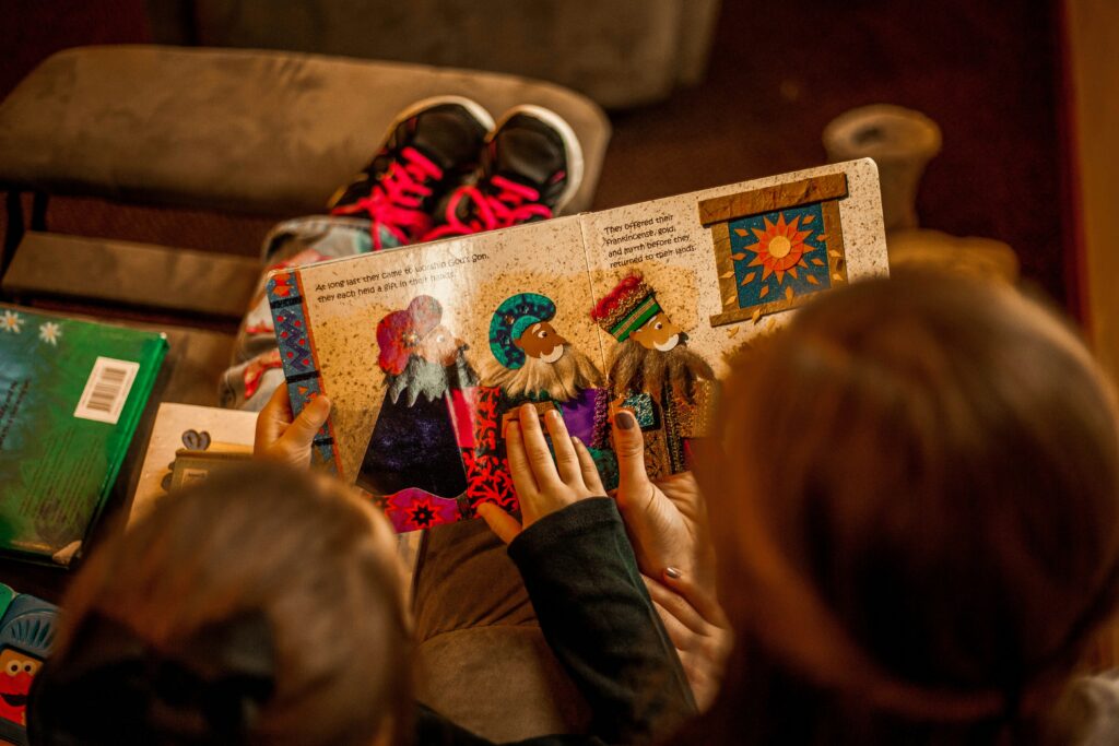 two kids reading a book about the three wise men together