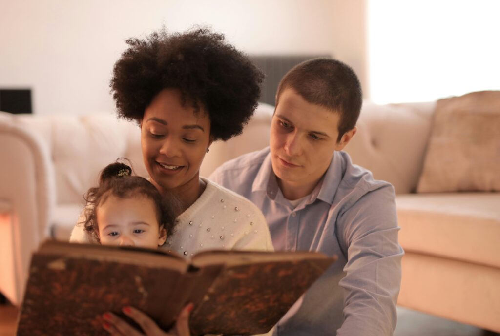 a man and woman read a children's book to a baby